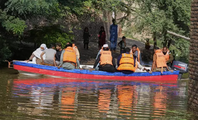 Rescue workers evacuate villagers from a flooded area in Muza Islam Wala, in Jhang district, Pakistan, Tuesday, Sept. 2, 2025. (AP Photo/K.M. Chaudary)