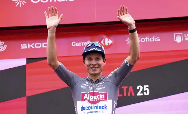 Belgian cyclist Jasper Philipsen celebrates at the podium after wining the nineteenth stage of the Spanish La Vuelta cycling race, from Rueda to Guijuelo, Spain, Friday, Sept. 12, 2025. (AP Photo/Manu Fernandez)