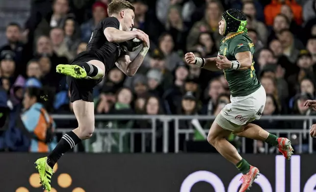 Damian McKenzie, left, of New Zealand and Cheslin Kolbe of South Africa compete for the ball during their rugby international at Eden Park in Auckland, New Zealand, Saturday, Sept. 6, 2025. (Andrew Cornaga/Photosport via AP)
