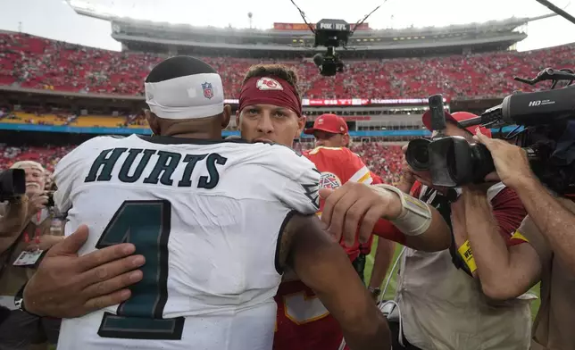 Kansas City Chiefs quarterback Patrick Mahomes and Philadelphia Eagles quarterback Jalen Hurts (1) hug following an NFL football game Sunday, Sept. 14, 2025, in Kansas City, Mo. (AP Photo/Charlie Riedel)