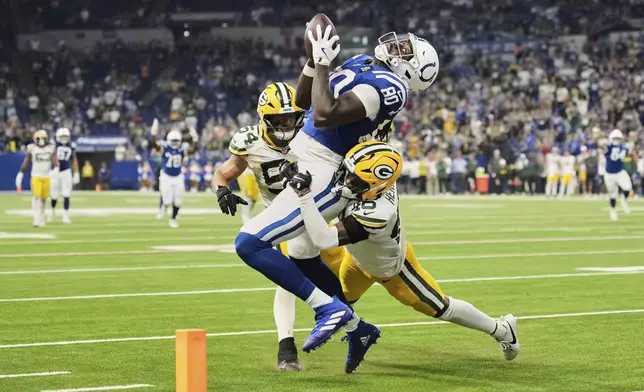 Indianapolis Colts tight end Jelani Woods (80) tries to make a catch while being hit by Green Bay Packers cornerback Tyron Herring (46) during a preseason NFL football game in Indianapolis, Indiana, Aug. 16, 2025. (AP Photo/AJ Mast)