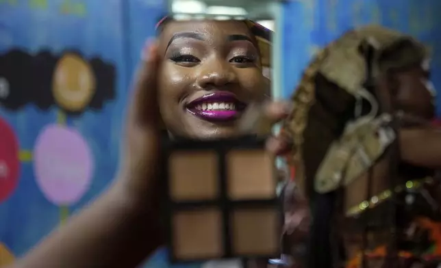A model is reflected in a mirror applying makeup during the Mr. and Mrs. Kibera leadership contest held on International Youth Day in Nairobi, Kenya, Aug. 12, 2025. (AP Photo/Brian Inganga)