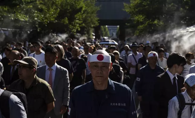 Visitors line up to offer prayers at the Yasukuni Shrine on the 80th anniversary of Japan's surrender in World War II in Tokyo, Aug. 15, 2025. (AP Photo/Louise Delmotte)