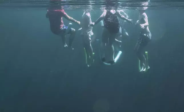 A family swims in Royal Spring, in Suwanne County, Florida, July 15, 2025. (AP Photo/Marta Lavandier)