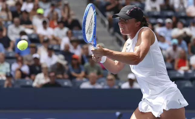 Iga Swiatek, of Poland, returns a shot against Ekaterina Alexandrova, of Russia, during the fourth round of the US Open tennis championships, Monday, Sept. 1, 2025, in New York. (AP Photo/Heather Khalifa)