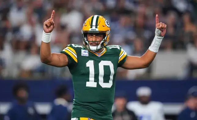 Green Bay Packers' Jordan Love (10) celebrates a touchdown run by Josh Jacobs (8) in the second half of an NFL football game against the Dallas Cowboys Sunday, Sept. 28, 2025, in Arlington, Texas. (AP Photo/Julio Cortez)