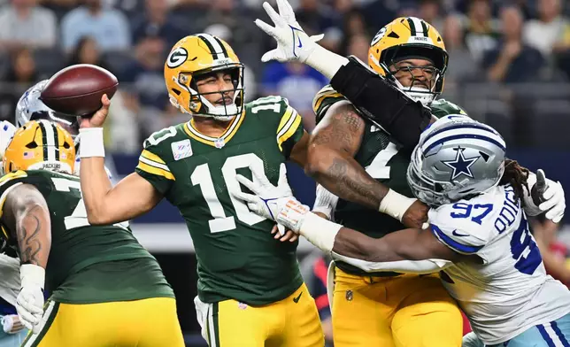 Green Bay Packers quarterback Jordan Love (10) throws a pass under pressure from Dallas Cowboys defensive tackle Osa Odighizuwa (97) in the first half of an NFL football game Sunday, Sept. 28, 2025, in Arlington, Texas. (AP Photo/Jessica Tobias)