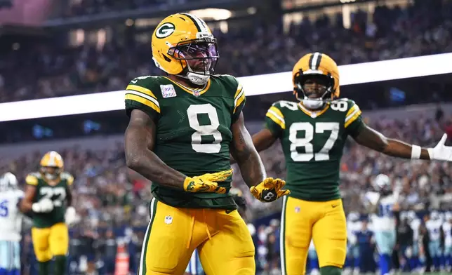 Green Bay Packers running back Josh Jacobs (8) and Romeo Doubs (87) celebrate a touchdown scored by Jacobs in the second half of an NFL football game against the Dallas Cowboys Sunday, Sept. 28, 2025, in Arlington, Texas. (AP Photo/Jessica Tobias)