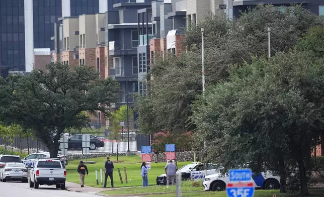 Police gather near an apartment building close to a U.S. Immigration and Customs Enforcement office after a shooting, in Dallas on Wednesday, Sept. 24, 2025. (AP Photo/Julio Cortez)