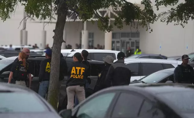 Law enforcement gather at a staging area close to a U.S. Immigration and Customs Enforcement office after a reported shooting, in Dallas on Wednesday, Sept. 24, 2025. (AP Photo/Julio Cortez)