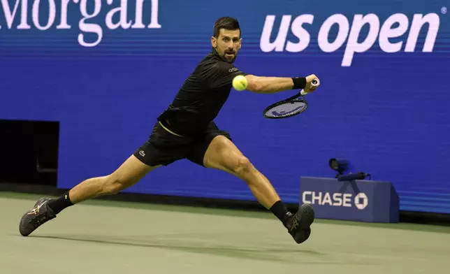 Novak Djokovic, of Serbia, returns a shot against Taylor Fritz, of the United States, during the quarterfinal round of the U.S. Open tennis championships, Tuesday, Sept. 2, 2025, in New York. (AP Photo/Adam Hunger)