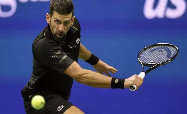 Novak Djokovic, of Serbia, returns a shot against Taylor Fritz, of the United States, during the quarterfinal round of the U.S. Open tennis championships, Tuesday, Sept. 2, 2025, in New York. (AP Photo/Adam Hunger)