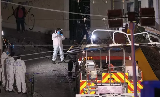 Members of the judicial police work at the site of a derailed electric streetcar in Lisbon, Portugal, Wednesday, Sept. 3, 2025. (AP Photo/Armando Franca)