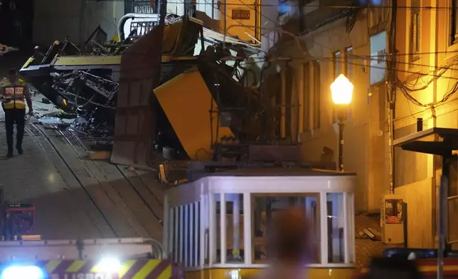 A police officer walks at the site of a derailed electric streetcar in Lisbon, Portugal, Wednesday, Sept. 3, 2025. (AP Photo/Armando Franca)