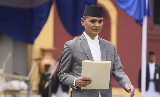New Home Minister Om Prakash Aryal walks after taking the oath of office by Nepalese President Ram Chandra Poudel, in front of the presidential building vandalized during recent protests, in Kathmandu, Nepal, Monday, Sept. 15, 2025. (AP Photo/Niranjan Shrestha)