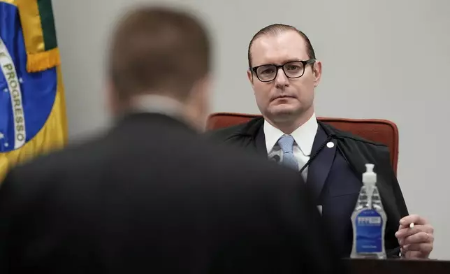 Lawyer for Gen. Augusto Heleno, who was the Minister of the Institutional Security Cabinet under Brazil's former President Jair Bolsonaro, left, speaks before Supreme Court Justice Cristiano Zanin, chairman of the panel, during the verdict and sentencing phase of a Supreme Court trial for those charged in an alleged coup plot to keep Bolsonaro in office after his 2022 election defeat, in Brasilia, Brazil, Wednesday, Sept. 3, 2025. (AP Photo/Eraldo Peres)