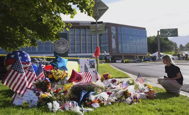 Meagan Bradley kneels at a memorial is set up for Charlie Kirk at Utah Valley University in Orem, Utah, Friday, Sept. 12, 2025. (AP Photo/Lindsey Wasson)
