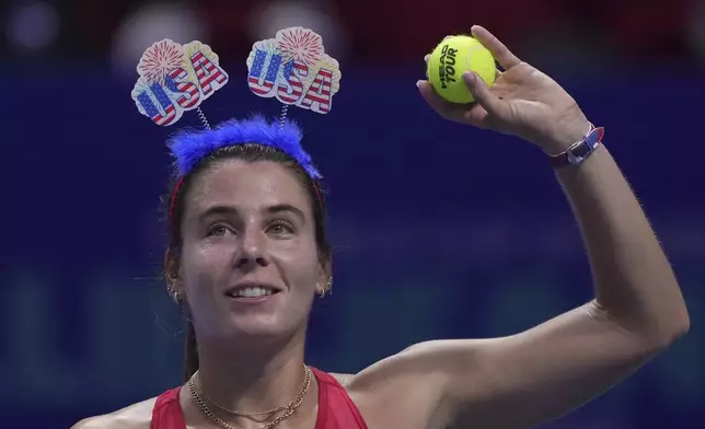 Emma Navarro, of the United States prepares to hit the ball to spectators after winning in the Billie Jean King Cup semifinals tennis match against Sonay Kartal, of Britain, at the Shenzhen Bay Sports Center Arena, in Shenzhen, China's Guangdong province, Saturday, Sept. 20, 2025. (AP Photo/Andy Wong)