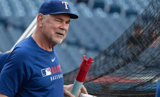 Texas Rangers manager Bruce Bochy watches his team during batting practice before the start of a baseball game against the Cleveland Guardians, Saturday, Sept. 27, 2025, in Cleveland. (AP Photo/Phil Long)
