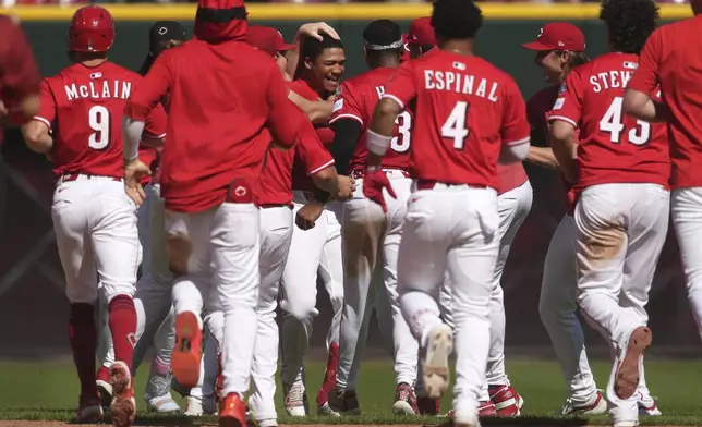 Cincinnati Reds' Noelvi Marte, center, celebrates with teammates after hitting a walkoff two-run single in the ninth inning of a baseball game against the Toronto Blue Jays, Monday, Sept. 1, 2025, in Cincinnati. (AP Photo/Kareem Elgazzar)