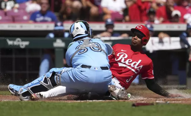 Cincinnati Reds' Ke'Bryan Hayes, right, is tagged out at home plate by Toronto Blue Jays' Alejandro Kirk, left, in the second inning of a baseball game Monday, Sept. 1, 2025, in Cincinnati. (AP Photo/Kareem Elgazzar)