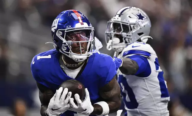 New York Giants wide receiver Malik Nabers (1) catches a pass as Dallas Cowboys cornerback Kaiir Elam (20) defends in the second half of an NFL football game Sunday, Sept. 14, 2025, in Arlington, Texas. (AP Photo/Jerome Miron)