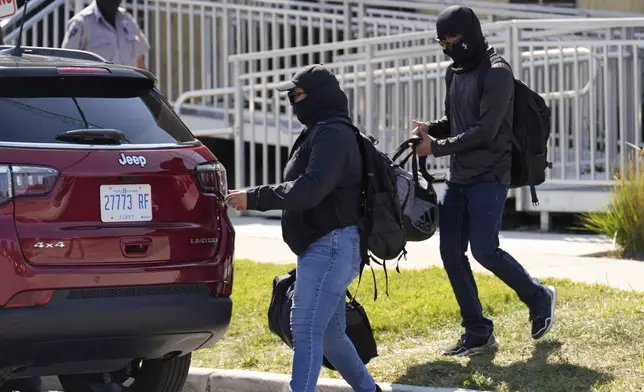Masked people leave an immigration processing center Monday, Sept. 8, 2025, in Broadview, Ill., a suburb of Chicago. (AP Photo/Carolyn Kaster)