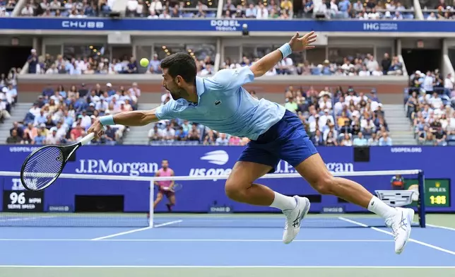 Novak Djokovic, of Serbia, returns a shot to Carlos Alcaraz, of Spain, during the men's singles semifinals of the U.S. Open tennis championships, Friday, Sept. 5, 2025, in New York. (AP Photo/Yuki Iwamura)