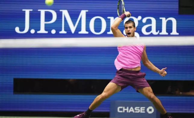 Carlos Alcaraz, of Spain, returns a shot to Novak Djokovic, of Serbia, during the men's singles semifinals of the U.S. Open tennis championships, Friday, Sept. 5, 2025, in New York. (AP Photo/Yuki Iwamura)