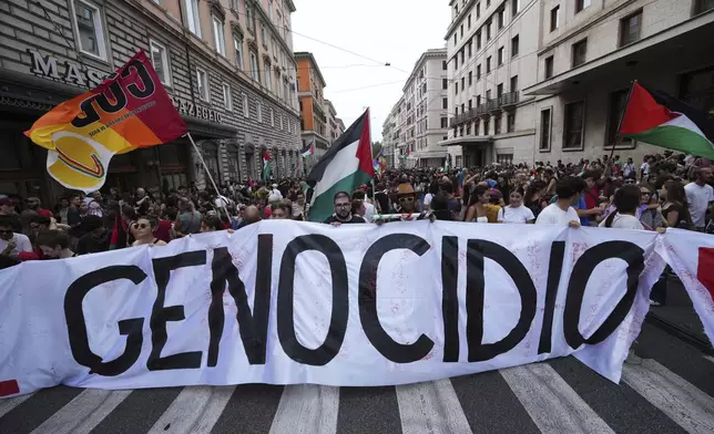 People hold a banner reading "genocide" as they participate at a demonstration part of a nation-wide protest and general strike against the war in Gaza, in Rome, Monday, Sept. 22, 2025. (AP Photo/Alessandra Tarantino)
