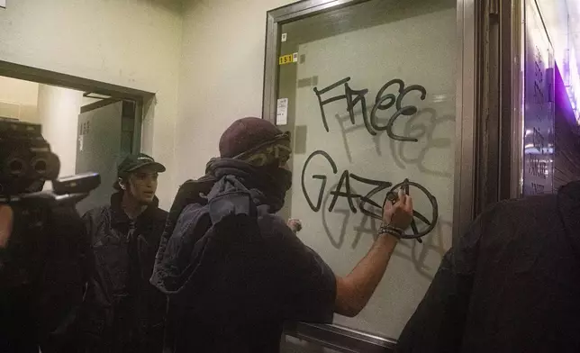 Protesters enter Central Station during clashes with police after the strike march in support of Palestine, in Milan, Italy, Monday, Sept. 22, 2025. (Marco Ottico/Lapresse via AP)