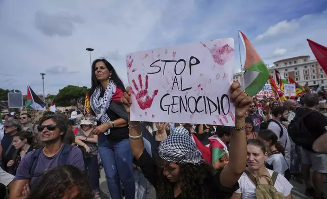 People hold banners reading "stop genocide"as they participate at a demonstration part of a nation-wide protest and general strike against the war in Gaza, in Rome, Monday, Sept. 22, 2025. (AP Photo/Alessandra Tarantino)
