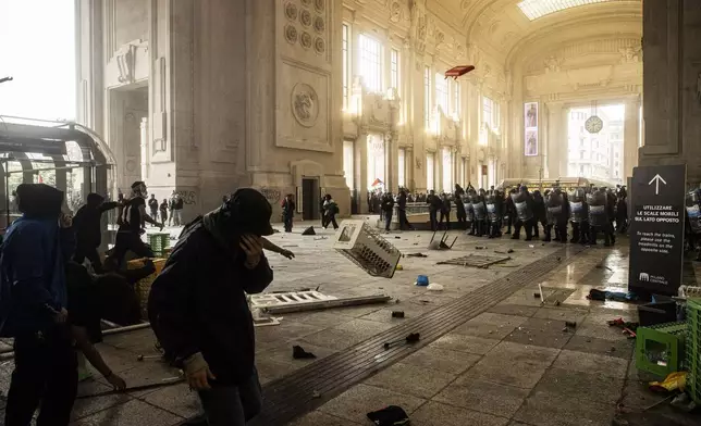 Protesters enter Central Station during clashes with police after the strike march in support of Palestine, in Milan, Italy, Monday, Sept. 22, 2025. (Marco Ottico/Lapresse via AP)
