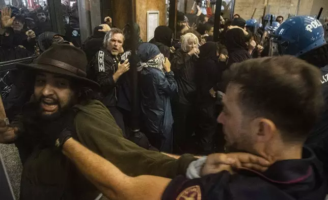 Protesters enter Central Station during clashes with police after the strike march in support of Palestine, in Milan, Italy, Monday, Sept. 22, 2025. (Marco Ottico/Lapresse via AP)