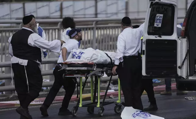 Israeli Zaka rescue and recovery team carry the body of a victim at the scene of shooting attack where several people killed and injured in Jerusalem, Monday, Sept. 8, 2025. (AP Photo/Mahmoud Illean)
