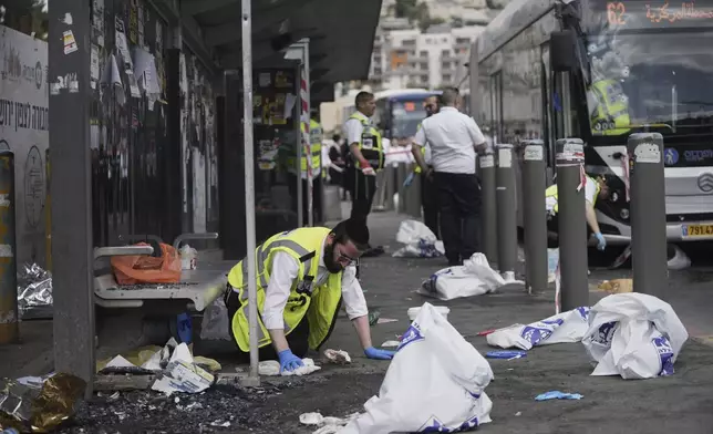 Israeli ZAKA rescue and recovery personnel clean bloodstains at the scene of a shooting attack where several people killed and injured at a bus stop in Jerusalem, Monday, Sept. 8, 2025. (AP Photo/Mahmoud Illean)