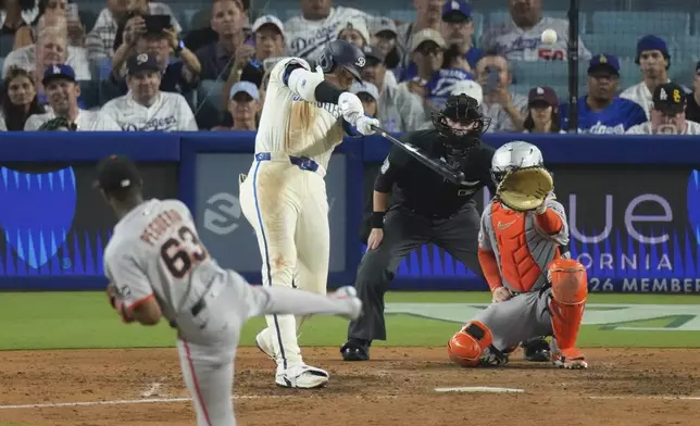 Los Angeles Dodgers' Shohei Ohtani, second from left, heads hits a solo home run as San Francisco Giants relief pitcher Joel Peguero, left, and catcher Patrick Bailey watch during the sixth inning of a baseball game, Saturday, Sept. 20, 2025, in Los Angeles. (AP Photo/Mark J. Terrill)