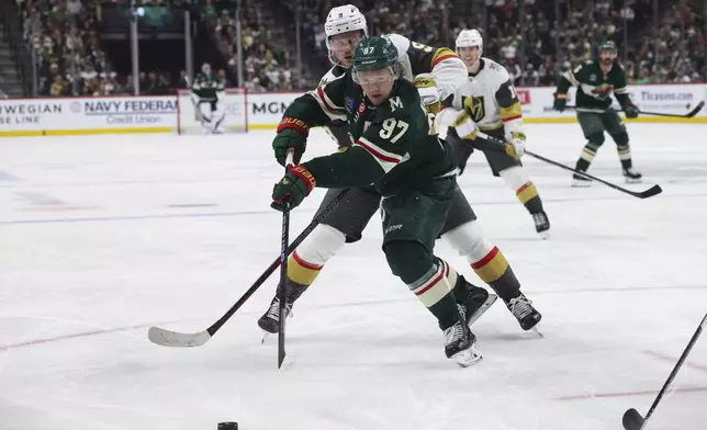 FILE - Minnesota Wild left wing Kirill Kaprizov (97) fights for the puck against Vegas Golden Knights center Jack Eichel (9) during the third period in Game 4 of an NHL hockey Stanley Cup first-round playoff series April 26, 2025, in St. Paul, Minn. Vegas won 4-3 in overtime. (AP Photo/Stacy Bengs, File)
