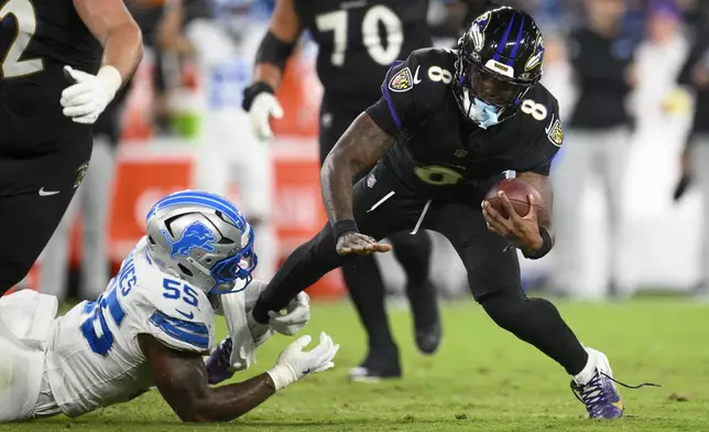 Baltimore Ravens quarterback Lamar Jackson (8) is tripped up by Detroit Lions linebacker Derrick Barnes (55) during the second half of an NFL football game Monday, Sept. 22, 2025, in Baltimore. (AP Photo/Nick Wass)