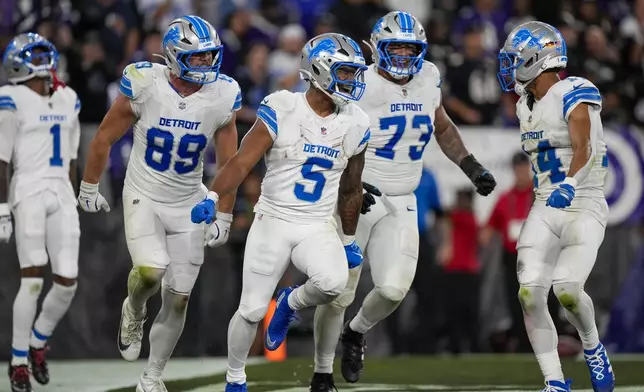 Detroit Lions running back David Montgomery (5) celebrates his touchdown run with teammates wide receiver Jameson Williams (1), tight end Brock Wright (89), guard Christian Mahogany (73) and wide receiver Amon-Ra St. Brown (14) during the second half of an NFL football game against the Baltimore Ravens Monday, Sept. 22, 2025, in Baltimore. (AP Photo/Stephanie Scarbrough)