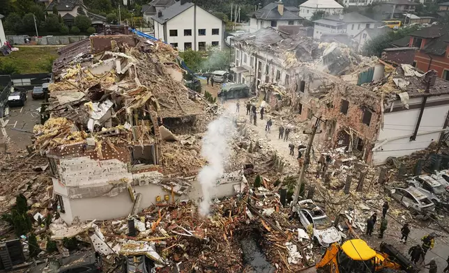 Rescuers work at the site of an apartment buildings damaged during a Russian attack in Kyiv, Ukraine, Sunday, Sept. 28, 2025. (AP Photo/Efrem Lukatsky)
