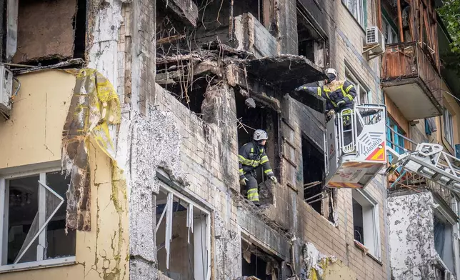 Rescuers work at the site of an apartment buildings damaged during a Russian attack in Kyiv, Ukraine, Sunday, Sept. 28, 2025. (AP Photo/Dan Bashakov)