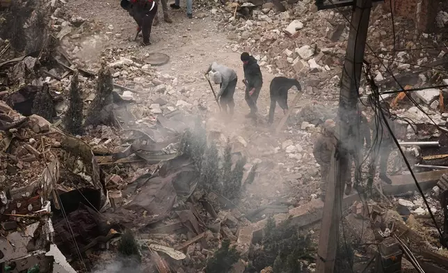 People clear the rubble at the site of an apartment buildings damaged during a Russian attack in Kyiv, Ukraine, Sunday, Sept. 28, 2025. (AP Photo/Efrem Lukatsky)