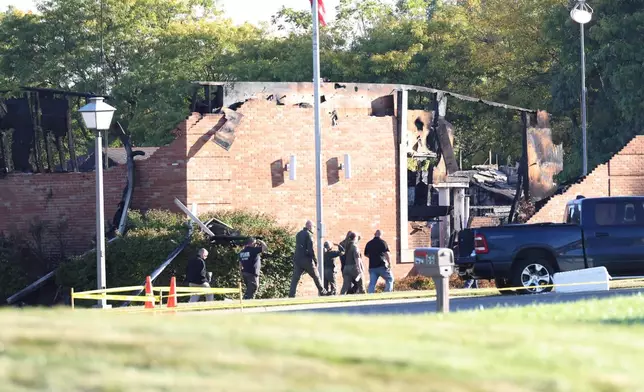 Law enforcement officers walk outside the Church of Jesus Christ of Latter-day Saints, Monday, Sept. 29, 2025 in Grand Blanc Township, Mich. (AP Photo/Carlos Osorio)