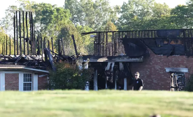 A law enforcement officer walks outside the Church of Jesus Christ of Latter-day Saints, Monday, Sept. 29, 2025 in Grand Blanc Township, Mich. (AP Photo/Carlos Osorio)