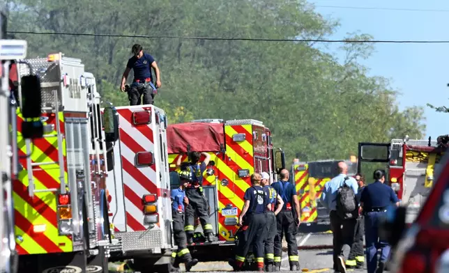 Fire department personnel stand along McCandlish Road near a shooting that took place at The Church of Jesus Christ of Latter-day Saints, Sunday, Sept. 28, 2025, in Grand Blanc, Mich. (AP Photo/Jose Juarez)