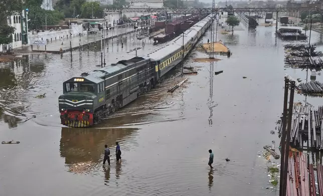 A commuter train leaves a railway station through flooded tracks caused by heavy rains, in Hyderabad, Pakistan, Tuesday, Sept. 9, 2025. (AP Photo/Pervez Masih)