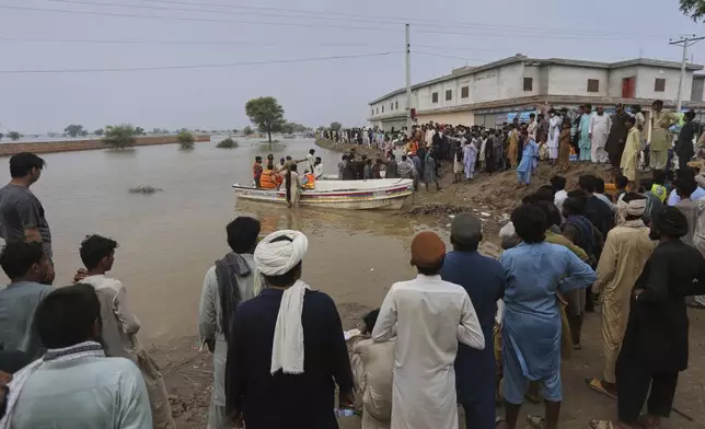Villagers get off from a boat after being evacuated by rescue workers from a flooded area following raising water level in rivers, in Jalalpur Pirwala, in Multan district, Pakistan, Monday, Sept. 8, 2025. (AP Photo/Asim Tanveer)