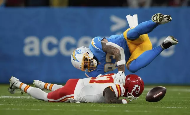 Los Angeles Chargers tight end Tyler Conklin fumbles over Kansas City Chiefs safety Chamarri Conner during the first half of an NFL football game, Friday, Sept. 5, 2025, in Sao Paulo. (AP Photo/Doug Benc)