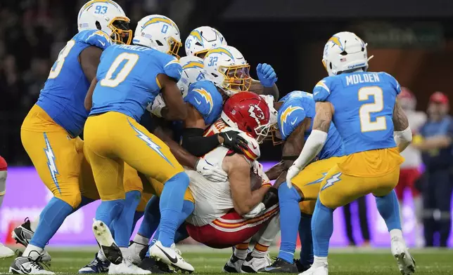Kansas City Chiefs tight end Travis Kelce is tackled by the Los Angeles Chargers during the first half of an NFL football game, Friday, Sept. 5, 2025, in Sao Paulo. (AP Photo/Doug Benc)